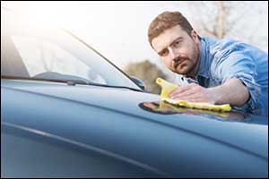 man cleaning black car
