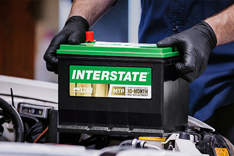 person adding interstate battery into a car