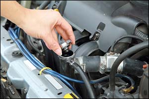man checking water in car radiator