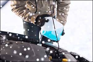 man adding coolent in car